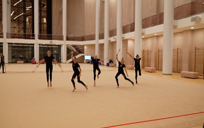 Alina Kabaeva makes the pirouette of Nicole Andronchik more difficult in the exercise with clubs