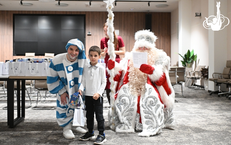 Участник новогодней елки в Академии единоборств во время получения подарка