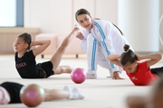 Coach Ekaterina Lots with gymnasts during practice at the training camp in the Academy