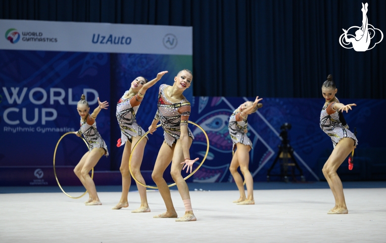 Group gymnasts during exercise with hoops and clubs