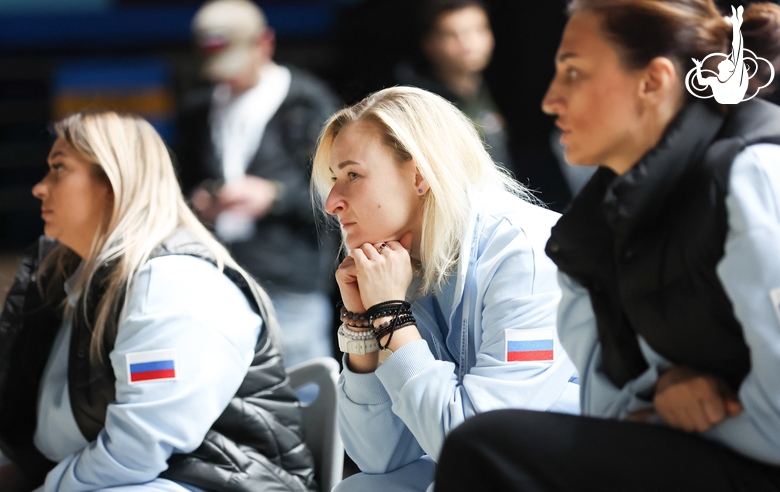 Coaches watch Academy students warm up before the start of the tournament