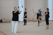 Coach Anna Ustsova with gymnasts during practice at the training camp in the Academy