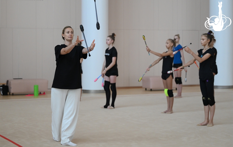 Coach Anna Ustsova with gymnasts during practice at the training camp in the Academy