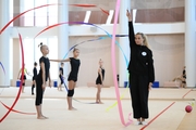 Coach Anna Ustsova with gymnasts during practice at the training camp in the Academy