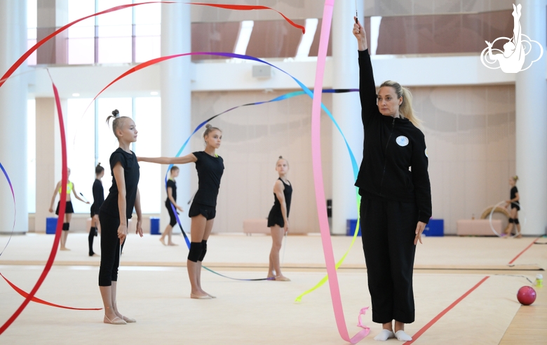Coach Anna Ustsova with gymnasts during practice at the training camp in the Academy