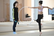 A coach and a gymnast from China during the hoop exercise when training