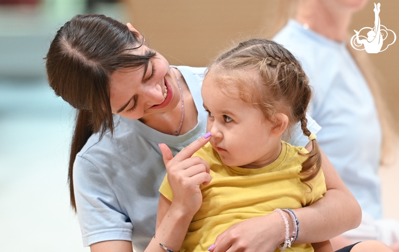 Academy coach Elizaveta Chernova with a young gymnast