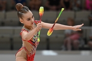 Young gymnast in an exercise with clubs during her performance at the All-Russian Formula of Victory competition