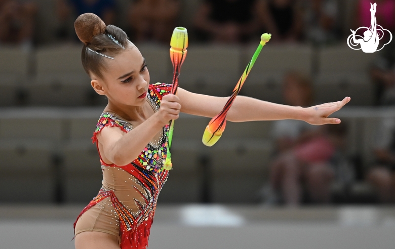 Young gymnast in an exercise with clubs during her performance at the All-Russian Formula of Victory competition