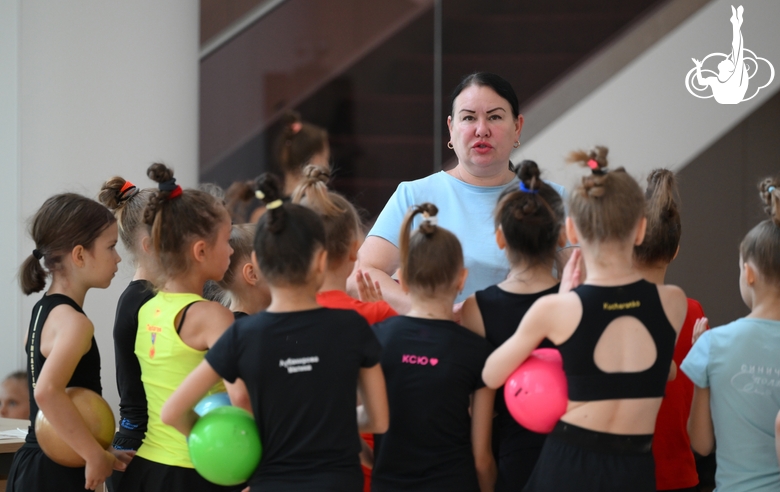 Coach Zlata Tulubaeva with gymnasts during practice at the training camp in the Academy