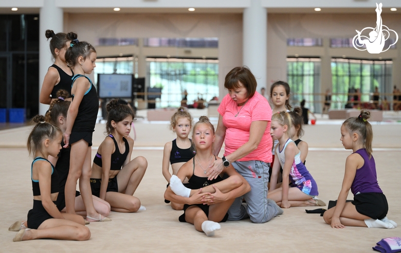 A gymnast with a coach during the training session