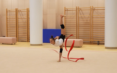Olympic champion Alina Kabaeva helps Mariia Borisova properly distribute her strength in her ribbon routine