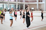 Coach Olga Minigalina with gymnasts during practice at the training camp in the Academy