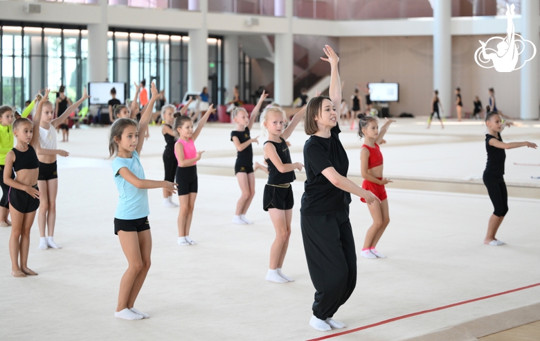 Coach Olga Minigalina with gymnasts during practice at the training camp in the Academy
