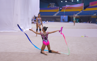 Alina Kabaeva helps Ksenia Savinova during the warm-up at the Sky Grace Cup in Qatar