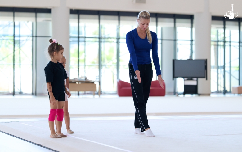 Coach Elizaveta Zorkina and young gymnasts during training