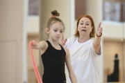 Coach Irina Kolesnikova and young gymnast  during training