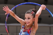 Happy gymnast does an exercise with a hoop during a performance at the Way to Victory tournament