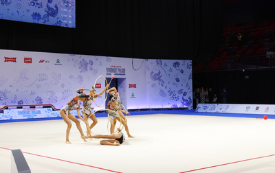 Алина Кабаева вместе с тренером Анной Усцовой помогает групповичкам Академии разобраться в перебросках в программе с обручами и булавами