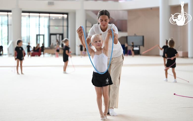 Coach Elizaveta Chernova and a young gymnast during training