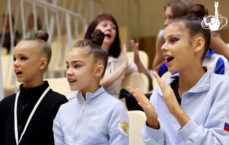 Kristina Voitenko, Ksenia Savinova and  Karolina Tarasova watch performance of gymnasts