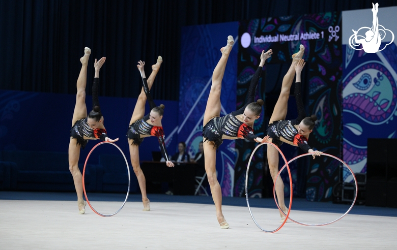 Group gymnasts during exercise with hoops and clubs